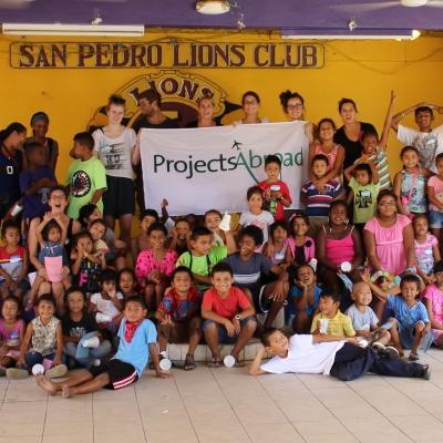 A group of Projects Abroad Childcare volunteers with a group of local children in Belize after their summer camp classes. Projects Abroad volunteers working with children in Belize celebrate the end of a successful summer camp with local children.